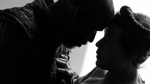 Macbeth and Lady Macbeth with foreheads touching in close-up