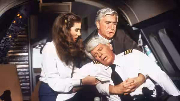 Woman and two men tend to unconscious pilot inside airplane cockpit