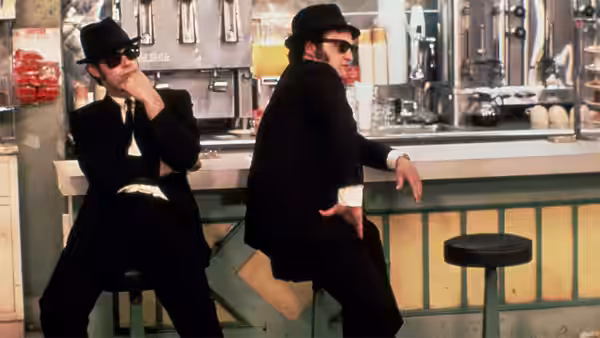 Jake Blues (John Belushi) and Elwood Blues (Dan Aykroyd) pose at a retro diner counter