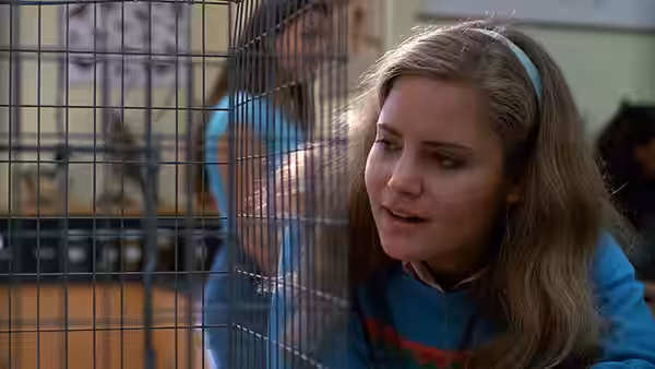 Stacy Hamilton (Jennifer Jason Leigh) looking through a wire cage in class