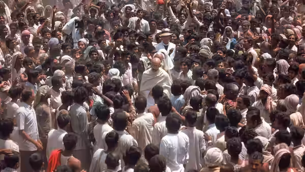 Gandhi (Ben Kingsley) moves through a dense crowd of supporters and followers