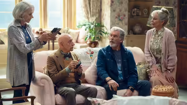 Elizabeth showing phone to Ibrahim and Ron while Joyce watches nearby