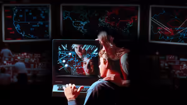 Jennifer (Ally Sheedy) seated before a monitor displaying maps and faces