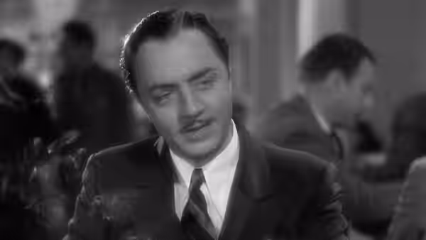 Godfrey (William Powell) sits among guests in a crowded room