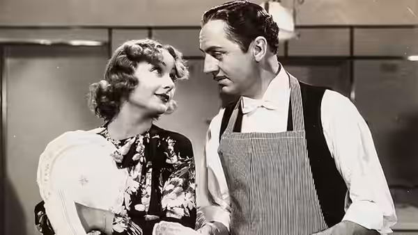 Irene Bullock (Carole Lombard) and Godfrey (William Powell) share a smile in the kitchen