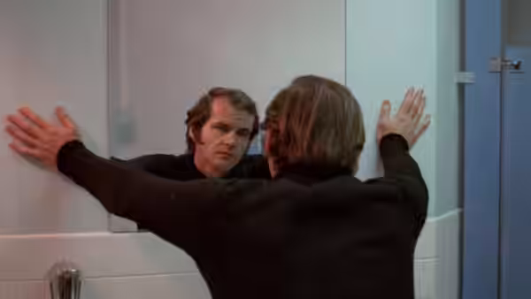 Robert Dupea (Jack Nicholson) stands before a mirror in a bathroom