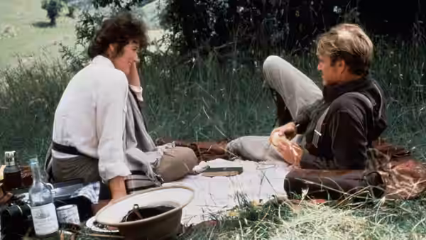 Karen Blixen (Meryl Streep) and Denys Finch Hatton (Robert Redford) talking on a picnic blanket