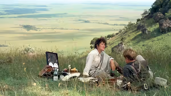 Karen Blixen (Meryl Streep) and Denys Finch Hatton (Robert Redford) picnicking on a hillside