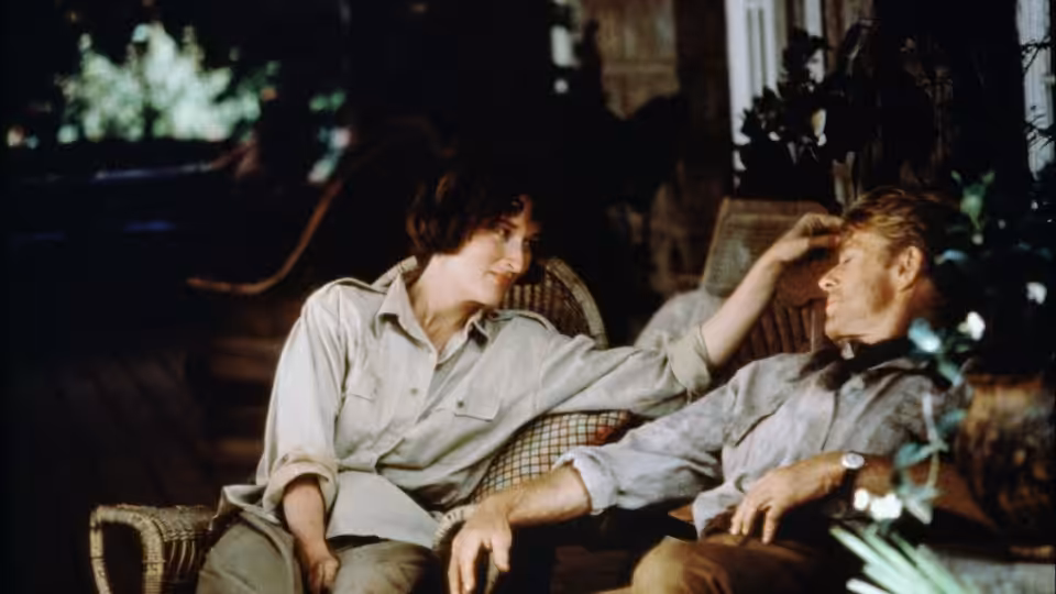 Karen Blixen (Meryl Streep) touching Denys Finch Hatton (Robert Redford) on a porch