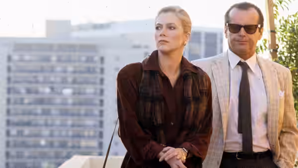 Irene Walker (Kathleen Turner) stands with Charley Partanna (Jack Nicholson) on a city balcony