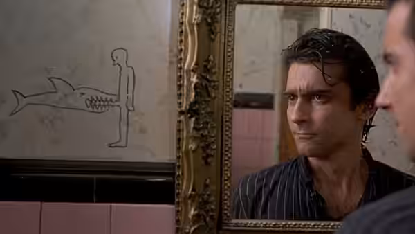 Paul Hackett (Griffin Dunne) studies his reflection beside a strange wall drawing