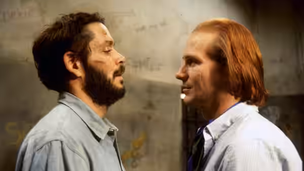 Valentin Arregui (Raul Julia) and Luis Molina (William Hurt) face each other closely