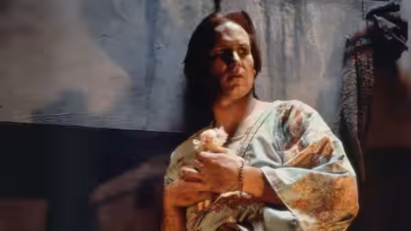 Luis Molina (William Hurt) holds a small figure while wearing a patterned robe