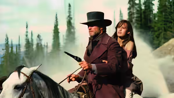 Preacher (Clint Eastwood) riding a horse holding a shotgun with a woman behind