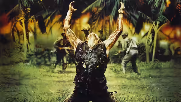 Sergeant Elias with arms raised in a burning jungle clearing