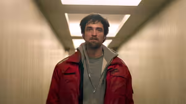 Connie Nikas in a red jacket stands in a brightly lit hallway