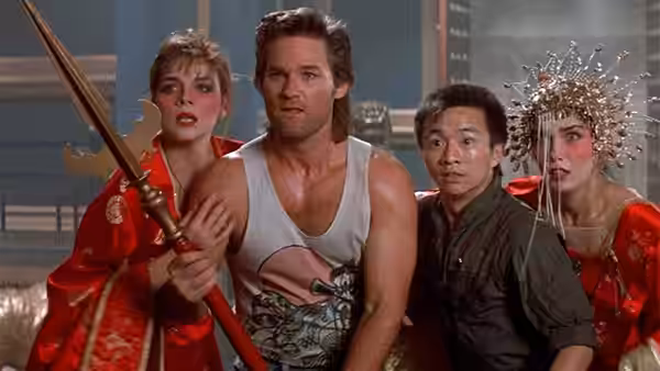 Jack Burton (Kurt Russell) stands beside a woman holding a spear among companions