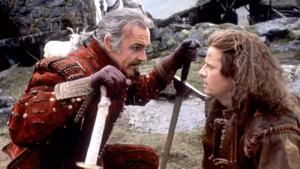 Ramirez (Sean Connery) holds a sword while facing Connor MacLeod (Christopher Lambert) among rocks