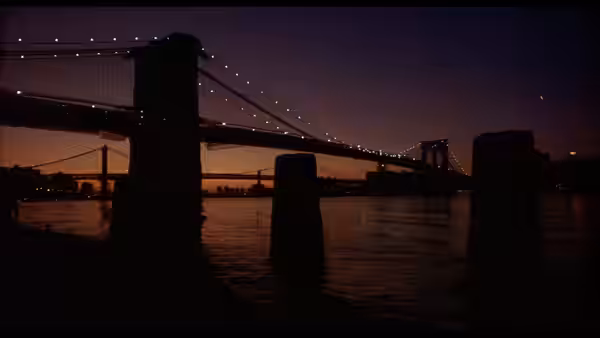 Brooklyn Bridge illuminated at dusk over the East River