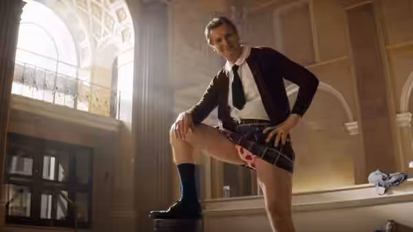 Frank Drebin Jr. (Liam Neeson) poses in school uniform in a grand hall