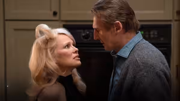 Beth Davenport (Pamela Anderson) faces Frank Drebin Jr. (Liam Neeson) closely in a kitchen