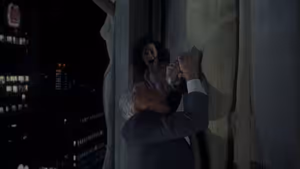 Frank Drebin (Leslie Nielsen) struggles with an assailant on a building ledge at night