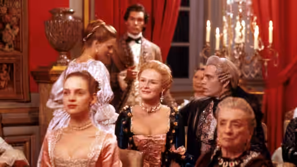 Glenn Close and John Malkovich sit among aristocrats at a formal gathering