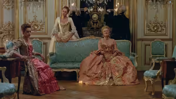 Glenn Close and two other women in ornate gowns inside a palace salon