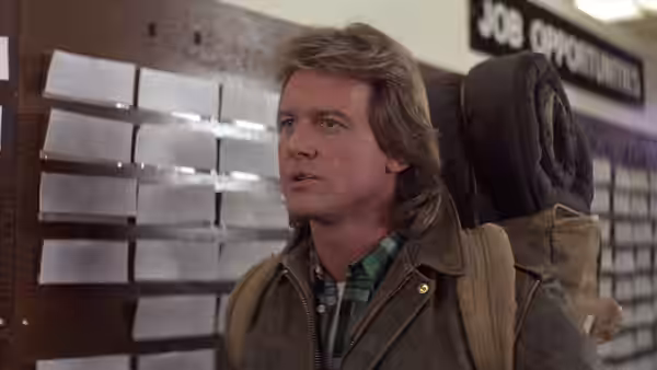 John Nada (Roddy Piper) standing before a job opportunities board