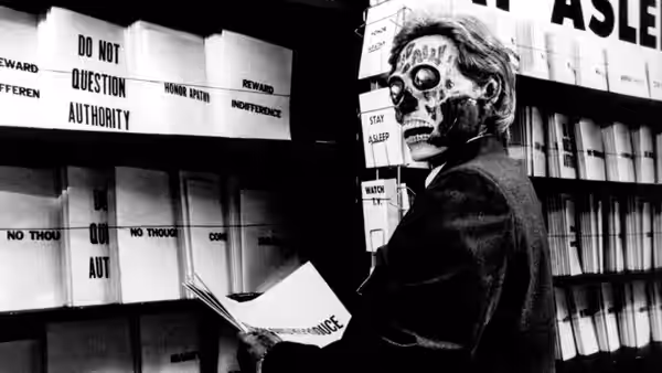 A skeleton-masked figure examining papers in a file room