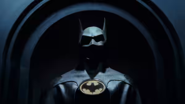 Batman (Michael Keaton) standing under a large stone archway in shadow