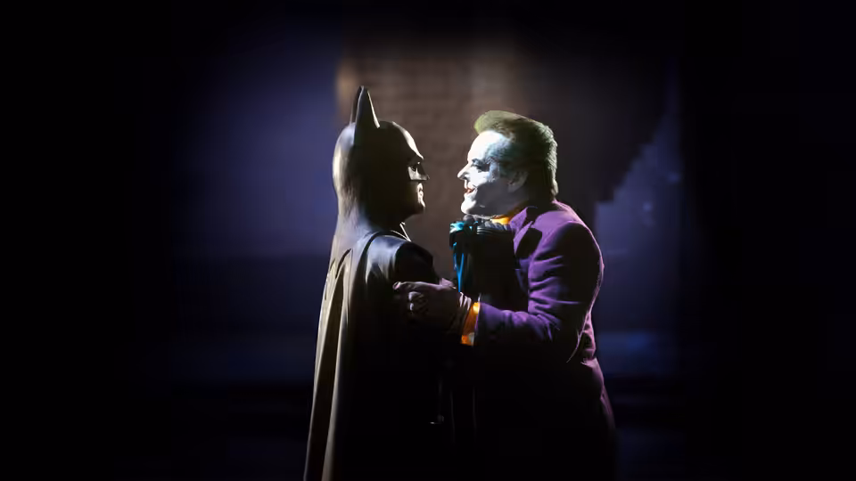 Joker (Jack Nicholson) gripping Batman (Michael Keaton) by the chest in darkness