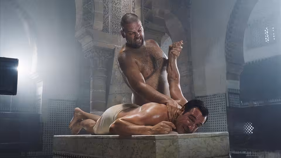Hubert Bonisseur de La Bath (Jean Dujardin) lies on a bathhouse table as an attendant scrubs him