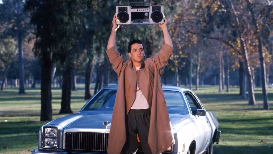 Lloyd Dobler (John Cusack) holding a boombox over his head beside a car