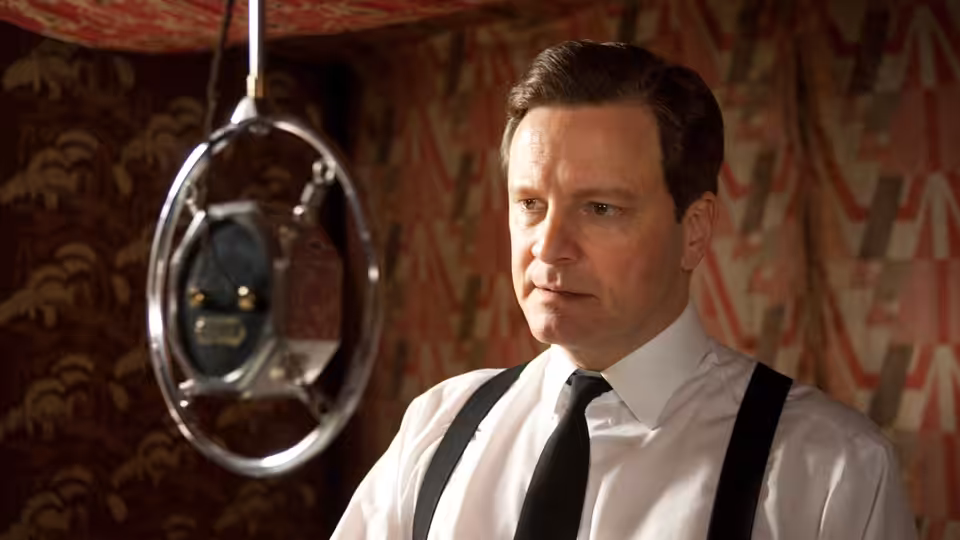 King George VI (Colin Firth) standing before a vintage studio microphone
