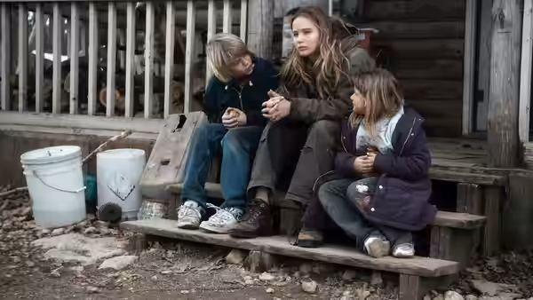 Ree Dolly with two children on wooden house steps