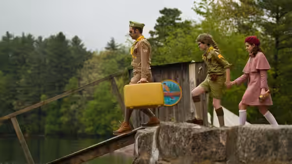 Captain Sharp (Bruce Willis) carrying a suitcase with two children on a bridge