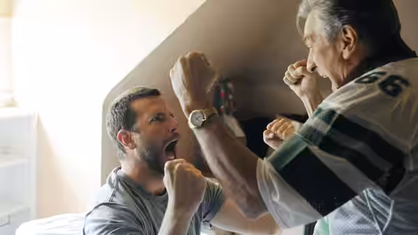 Pat (Bradley Cooper) and Pat Sr. (Robert De Niro) raising fists in a bedroom