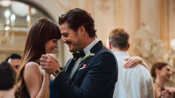 Lucy (Dakota Johnson) dancing closely with John (Chris Evans) at a formal event