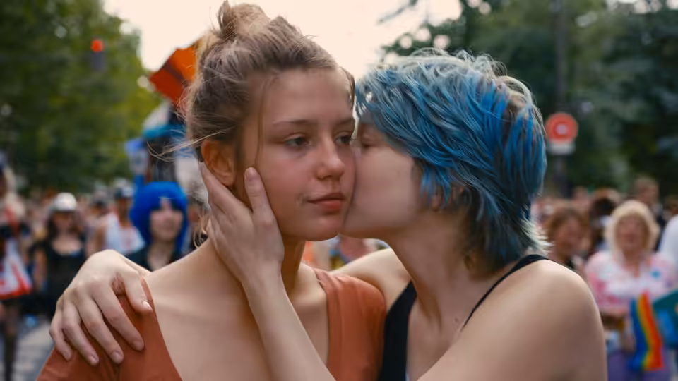 Adèle (Adèle Exarchopoulos) embraced by Emma (Léa Seydoux) at a crowded outdoor event