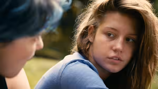 Adèle (Adèle Exarchopoulos) looking toward Emma with blue hair visible nearby