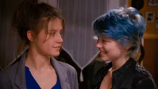 Adèle (Adèle Exarchopoulos) and Emma (Léa Seydoux) facing each other indoors and smiling