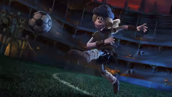 Goona kicks a football across the stadium pitch