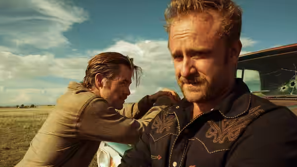 Chris Pine rests a hand on Jeff Bridges' shoulder beside a damaged vehicle