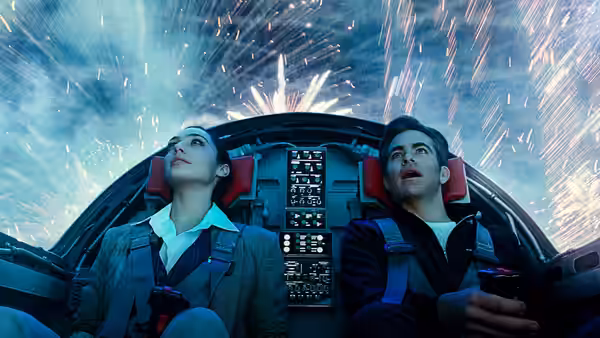 Diana Prince (Gal Gadot) and Steve Trevor (Chris Pine) ride in a cockpit as fireworks streak overhead
