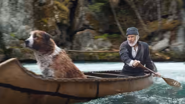 John Thornton (Harrison Ford) paddles a canoe downriver with Buck beside him