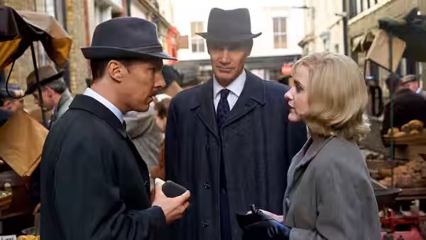 Greville Wynne (Benedict Cumberbatch) speaks with Oleg Penkovsky (Merab Ninidze) and a woman in a market
