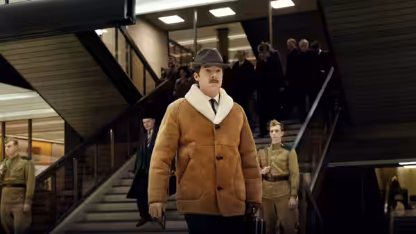 Greville Wynne (Benedict Cumberbatch) walks through a building flanked by uniformed guards
