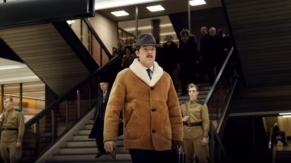 Greville Wynne (Benedict Cumberbatch) walks through a building flanked by uniformed guards