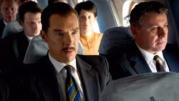 Greville Wynne (Benedict Cumberbatch) sits beside a passenger aboard an airplane
